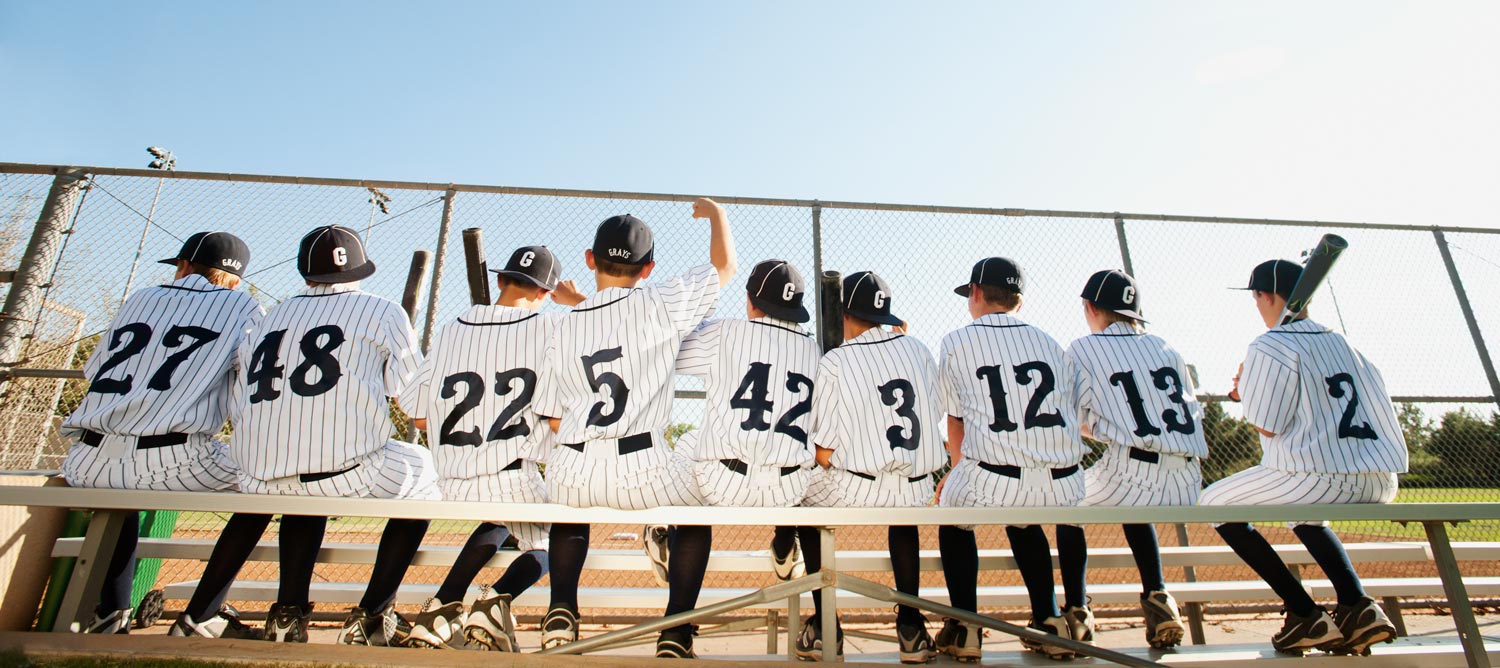 USA, California, Ladera Ranch, Boys (10-11) from little league sitting on bench, rear view