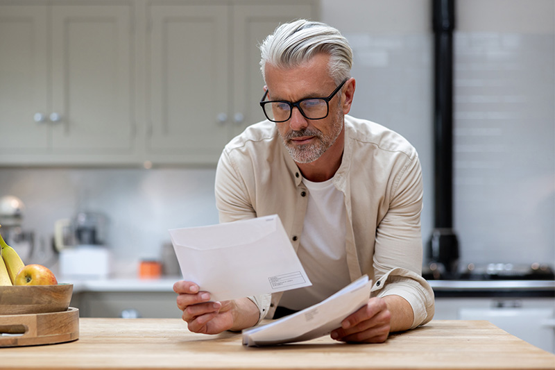 Middle-aged man looking through health related direct mail