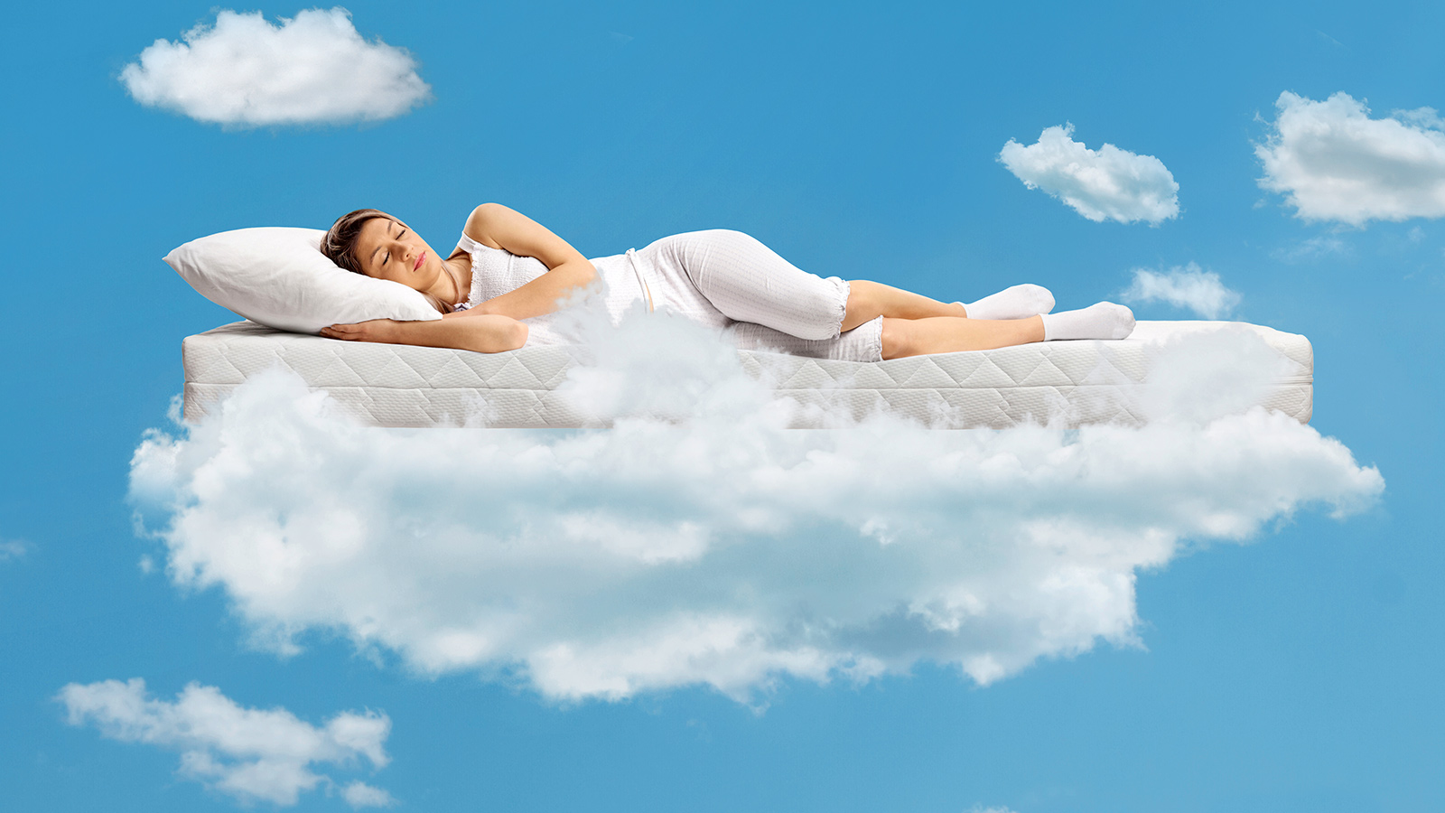 Woman sleeping on mattress in the clouds