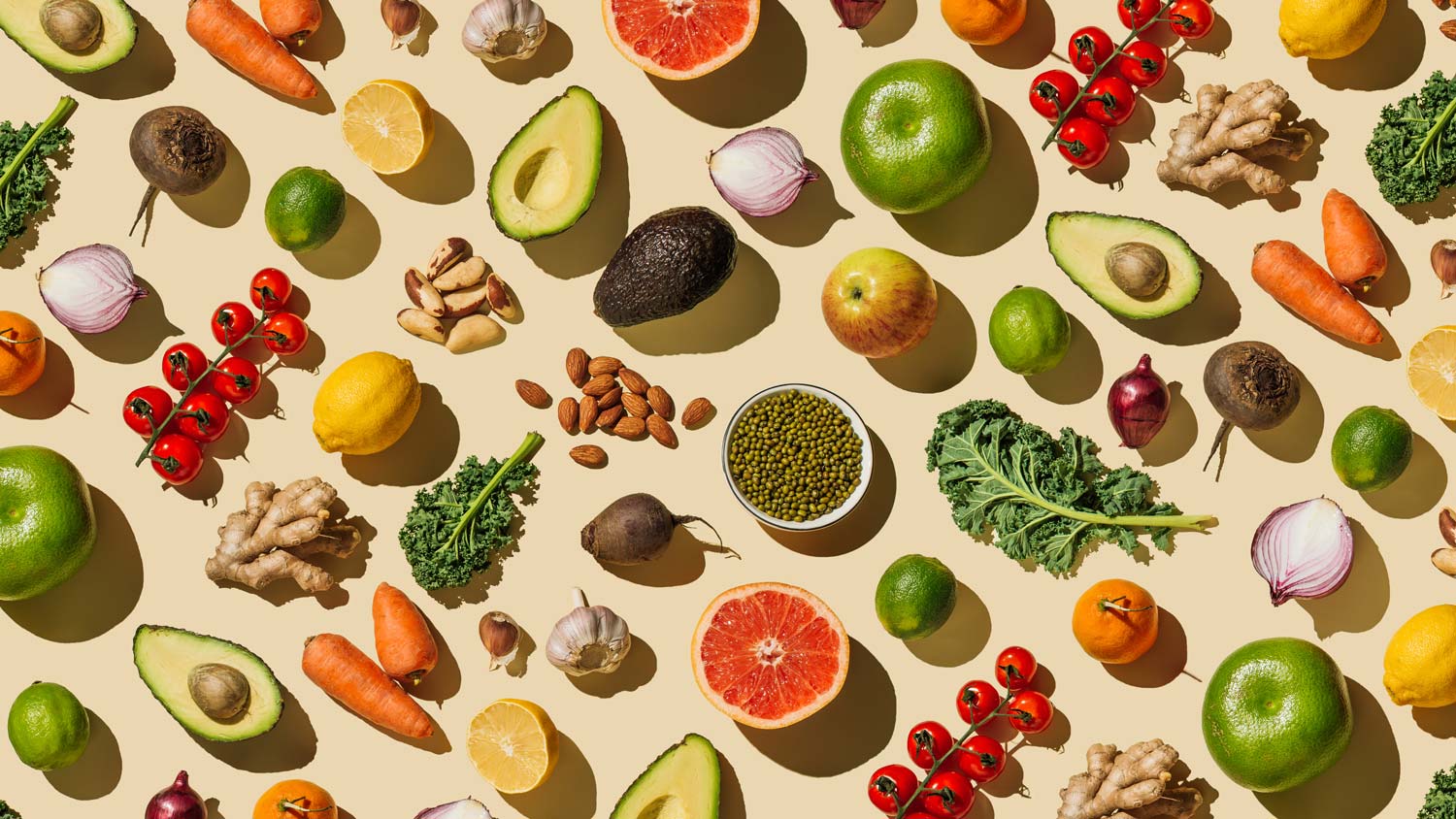 Pattern of variety fresh of organic fruits and vegetables and healthy vegan meal ingredients on beige background. Healthy food, clean eating, diet and detox, eco friendly, no plastic concept. Flat lay, top view