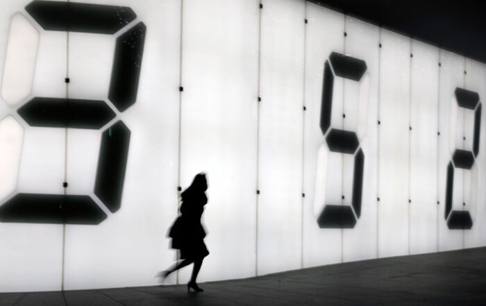 One female pedestrian walking on the street against a digital display wall