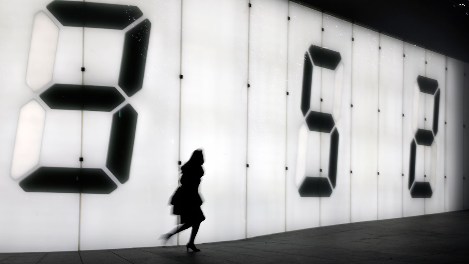 One female pedestrian walking on the street against a digital display wall