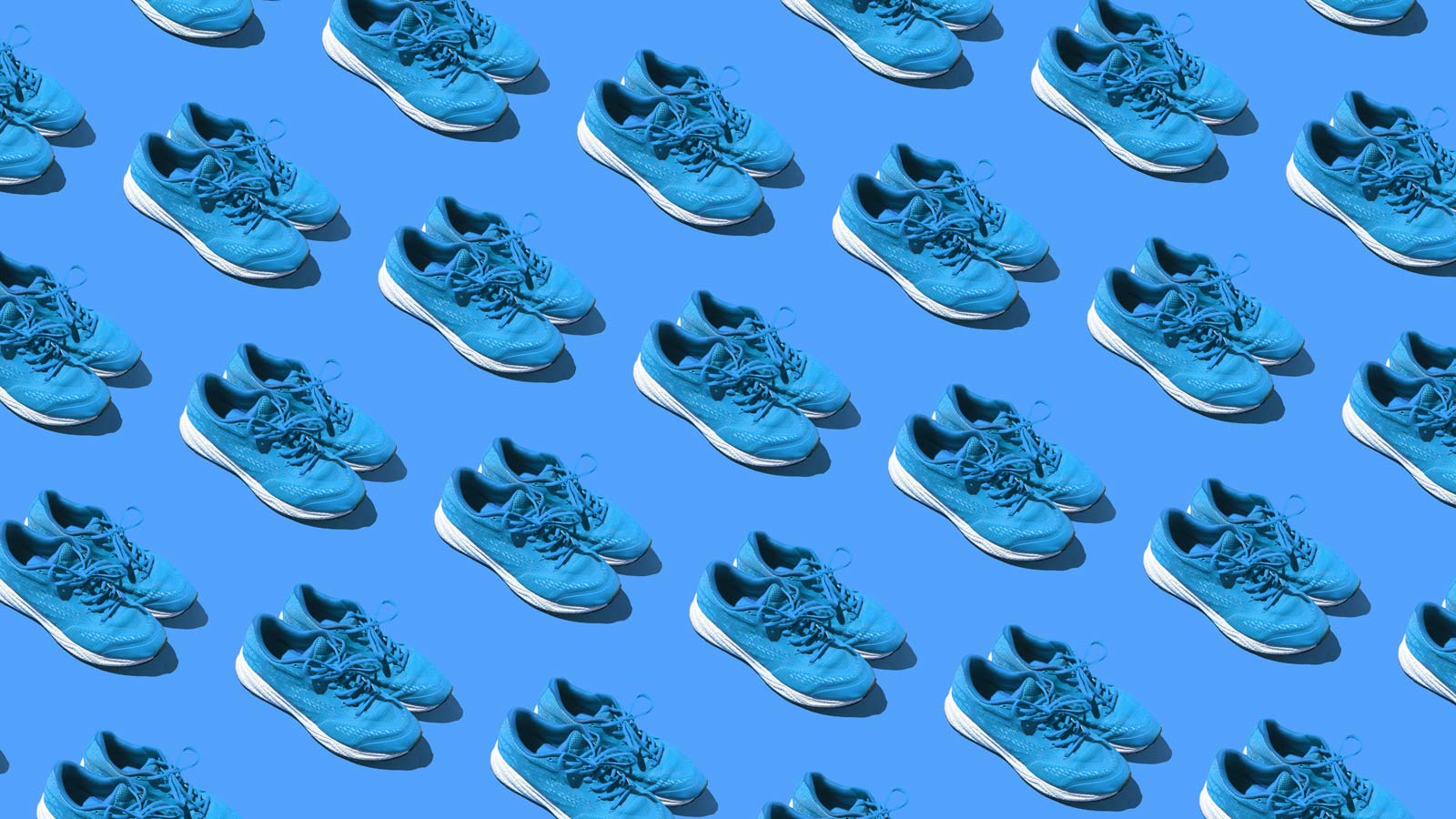 Pattern of used blue sneakers on a blue background. Concept of exercise, marathon, race, healthy life, training and comfort
