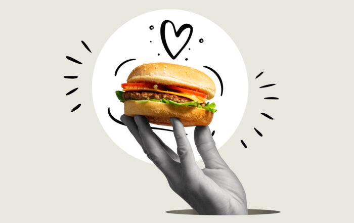 Emphasis markings and heart surround a hand holding a hamburger like a trophy.