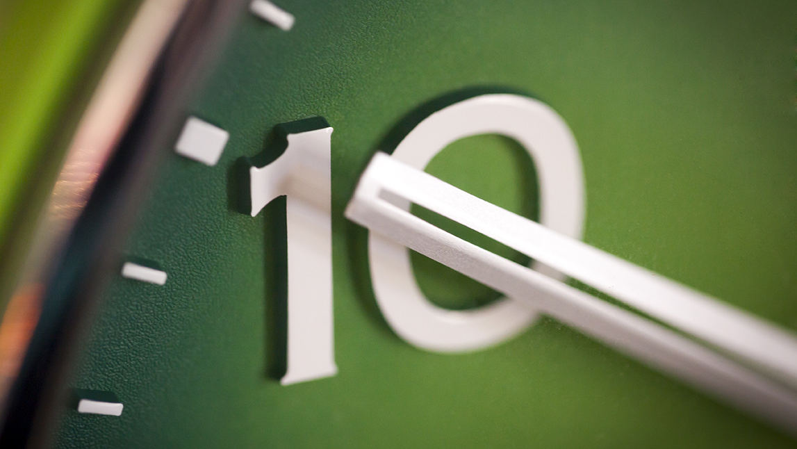 Up close on ten mark of green clock face