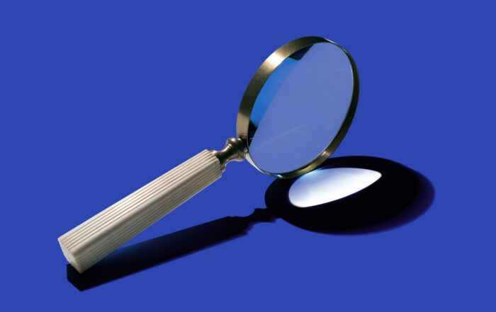 sideview of magnifying glass on blue background
