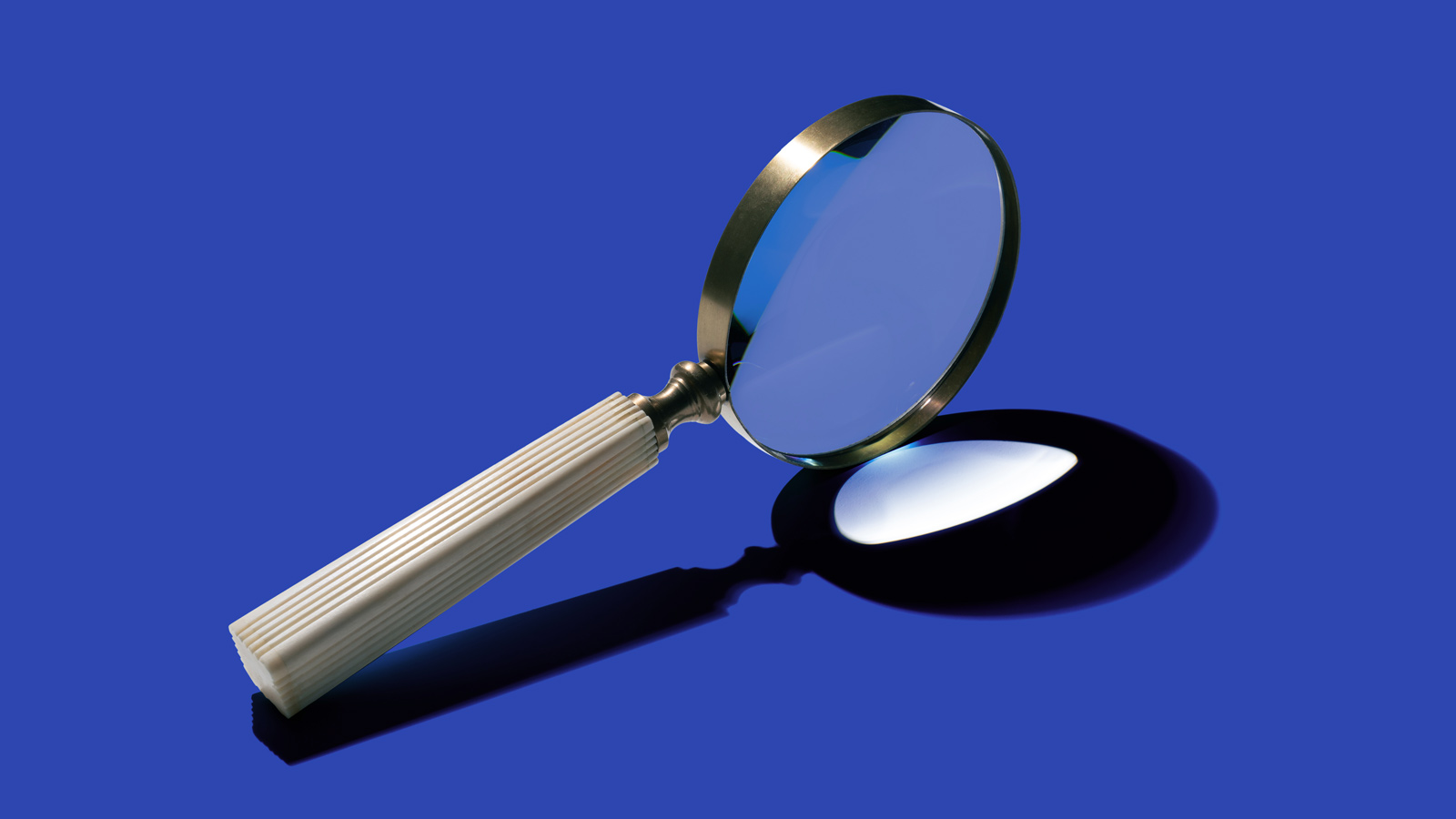 sideview of magnifying glass on blue background