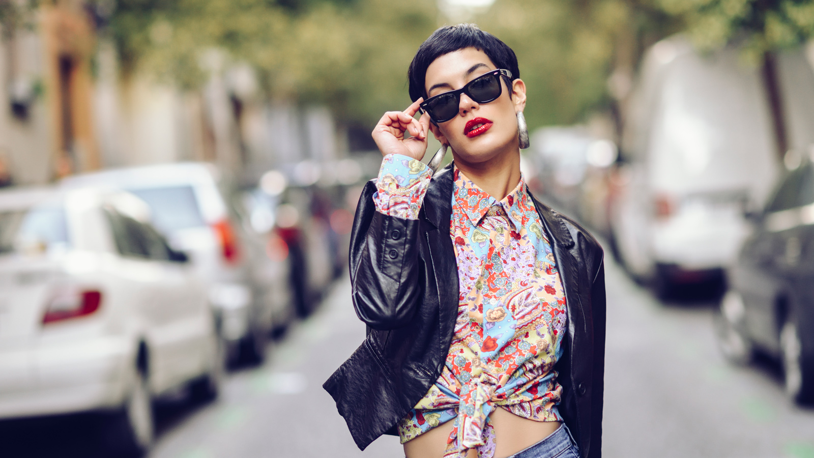 Portrait of fashionable young woman wearing sunglasses and leather jacket