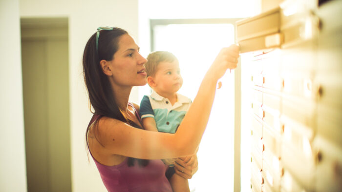 Person holding child while getting mail