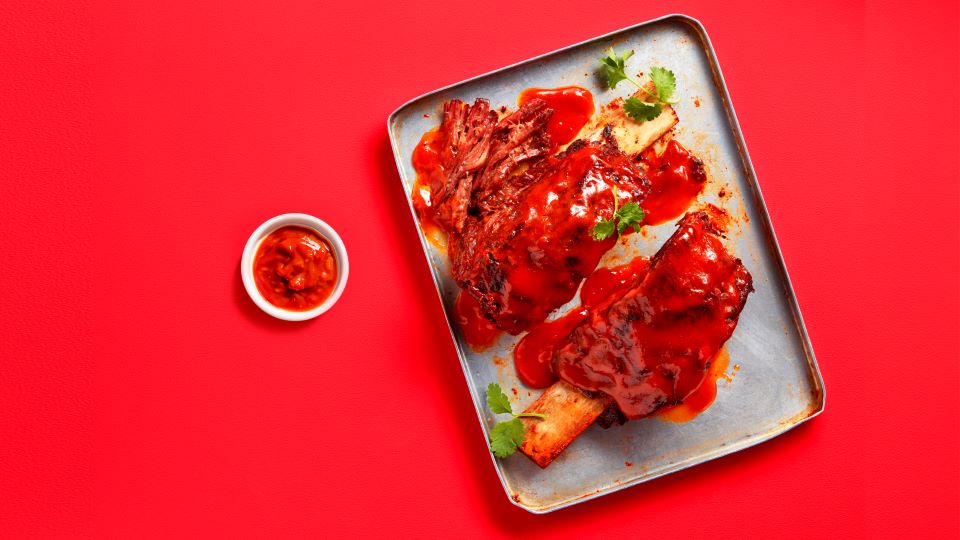 Una deliciosa porción de costillas de barbacoa en un plato, lista para disfrutar.