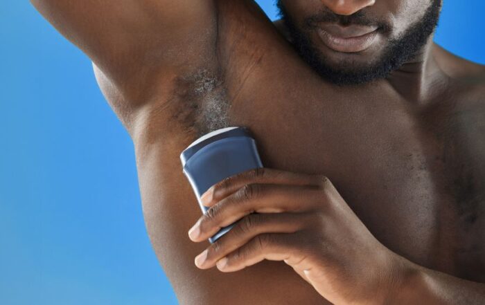 Man applying deodorant to his underarm