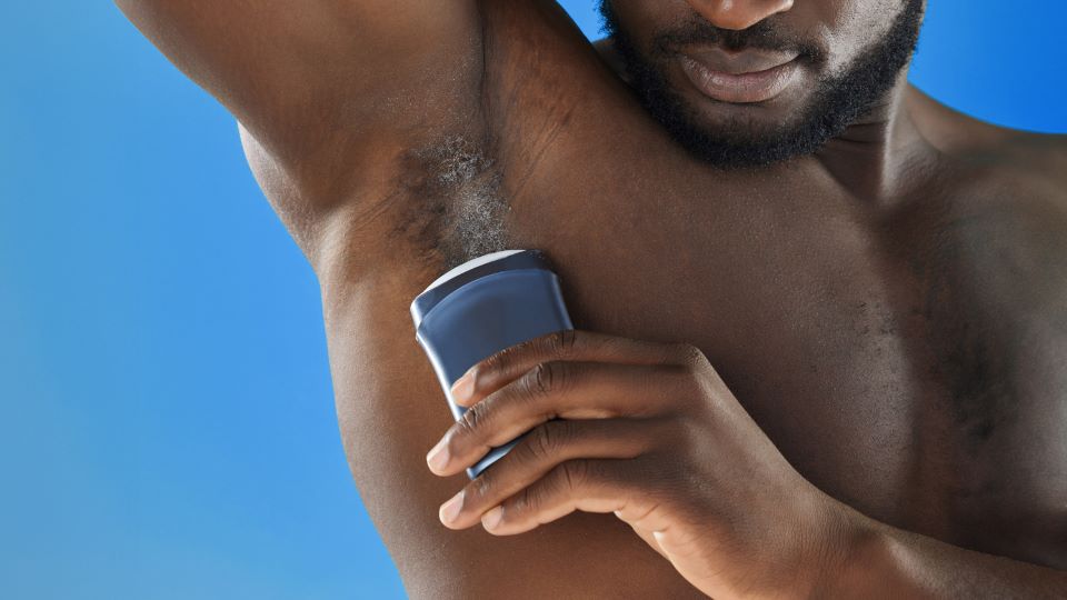 Man applying deodorant to his underarm