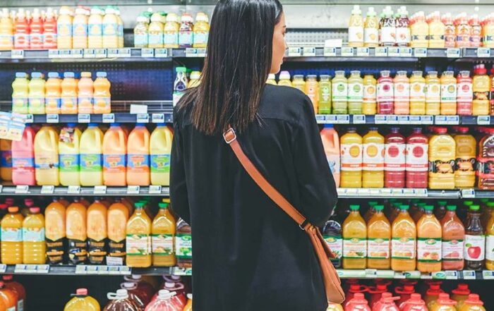 Person in a grocery market looking at shelves of juice