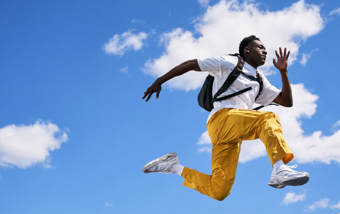Person wearing a backpack and leaping through the air