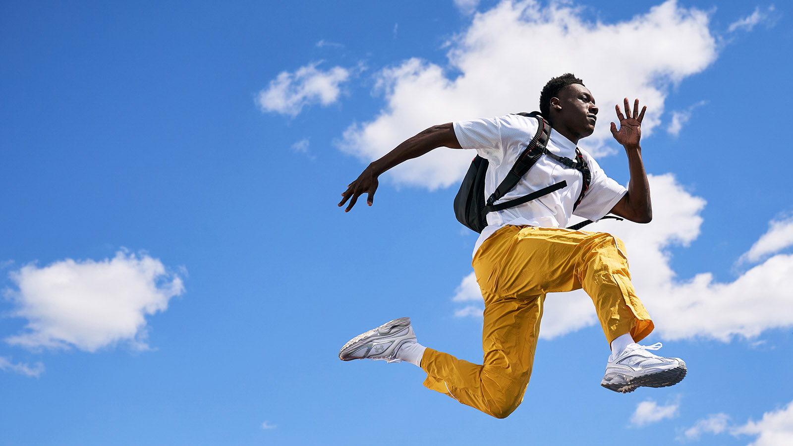 Person wearing a backpack and leaping through the air