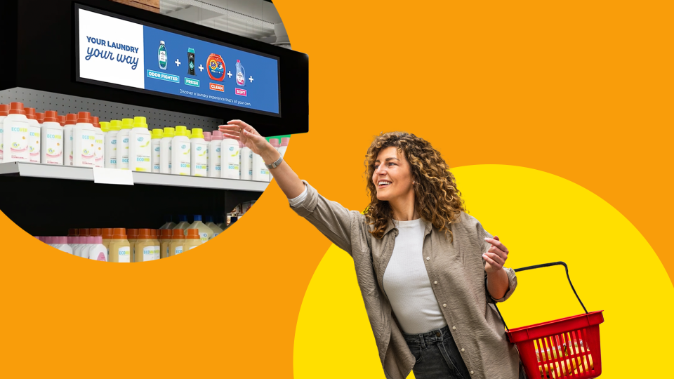 Person reaching for CPG products displayed on an end-cap with a retail media network screen