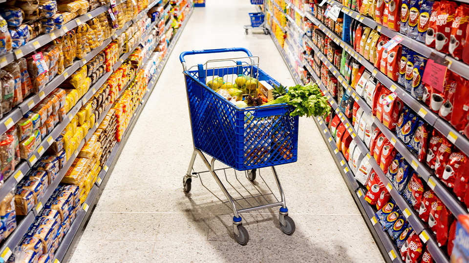 Full shopping cart in grocery aisle illustrating the moment of purchase influenced by in-store retail media networks.