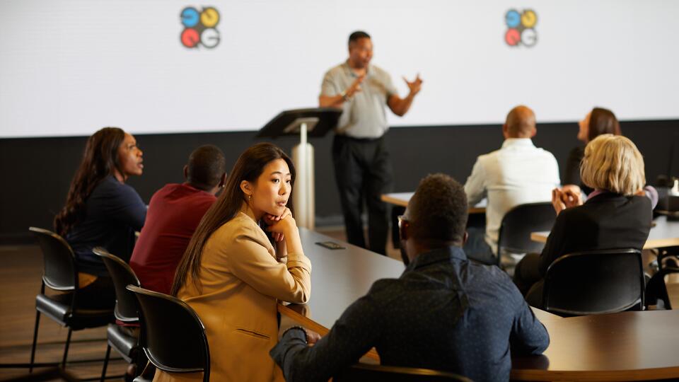 A group of people in a Quad branded classroom.