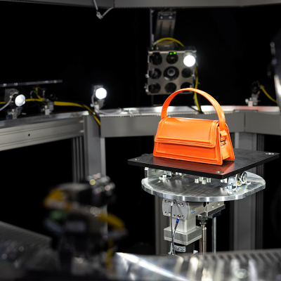 An orange handbag being 3D scanned with 3D Commerce by Quad