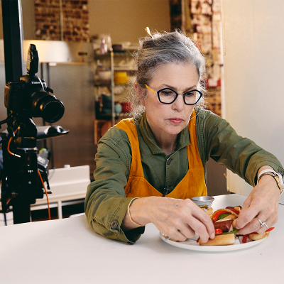 A creative production employee staging food for a photo shoot