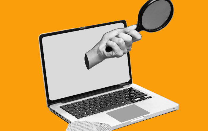 A hand holding a magnifying glass emerging from a laptop screen with a newspaper cutout in the bottom left corner of the image. The background is orange.