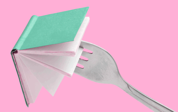 Eating your words with a fork poking an opened book in front of a pink background