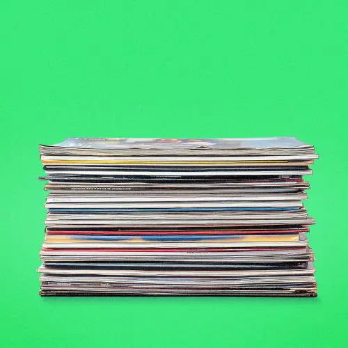 A stack of magazines and catalogs on a green background