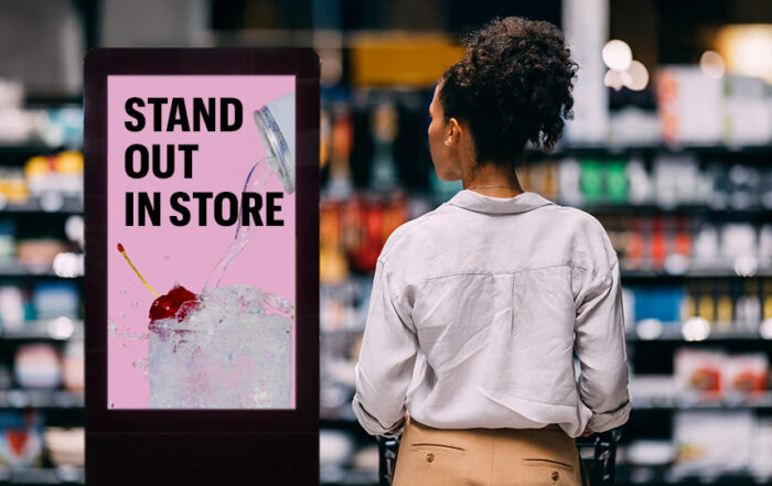 A consumer seeing an in-store display for a beverage that says: "Stand out in store"