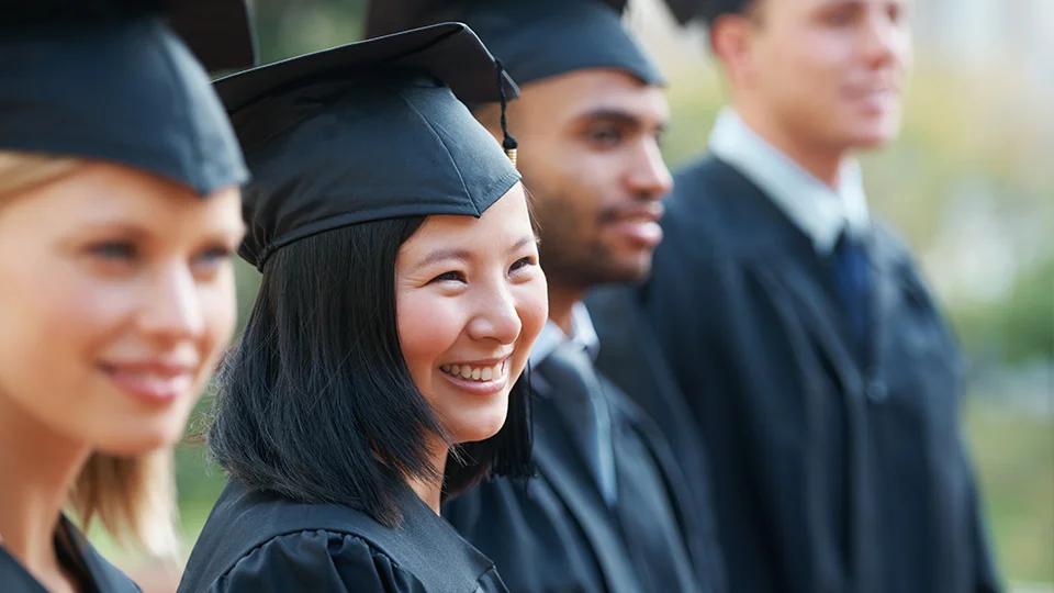 University students on graduation day in cap and gown
