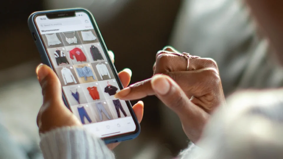 A shopper scrolling through social media, looking for clothing inspiration